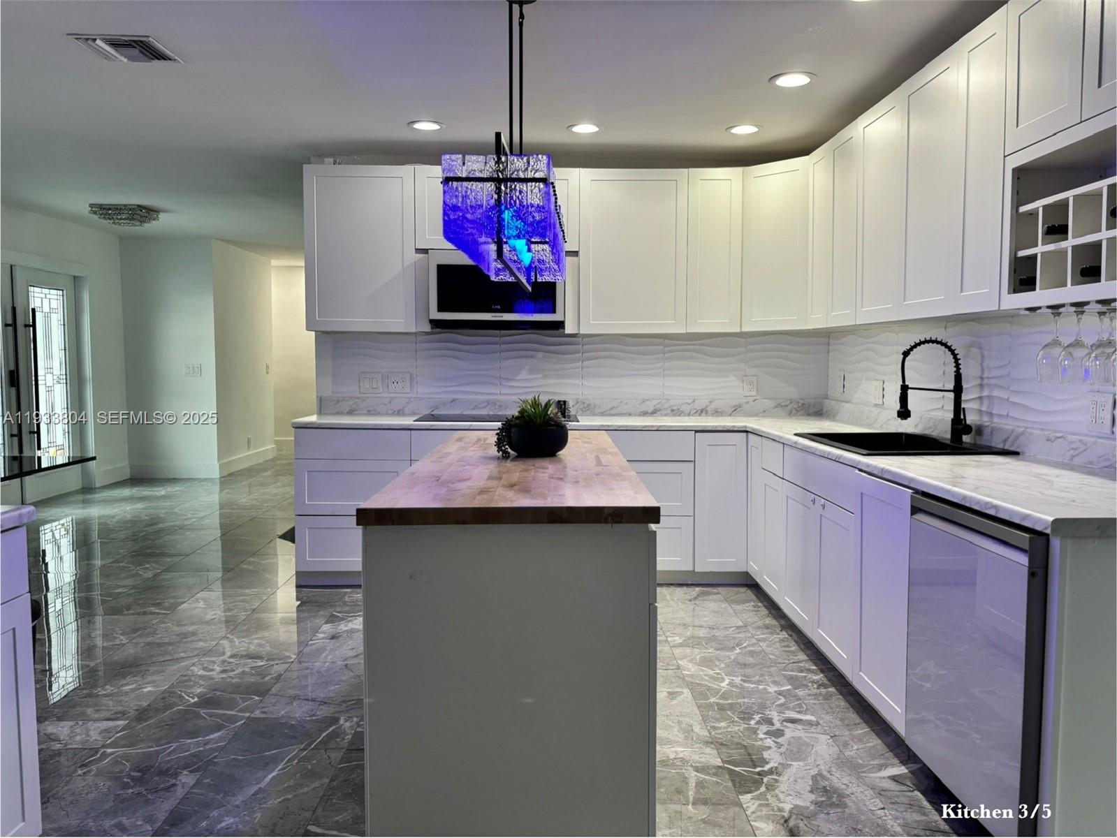 607 Maple Drive Margate, FL 33063 - Photo 26 of 37 a kitchen with kitchen island a sink stainless steel appliances and cabinets