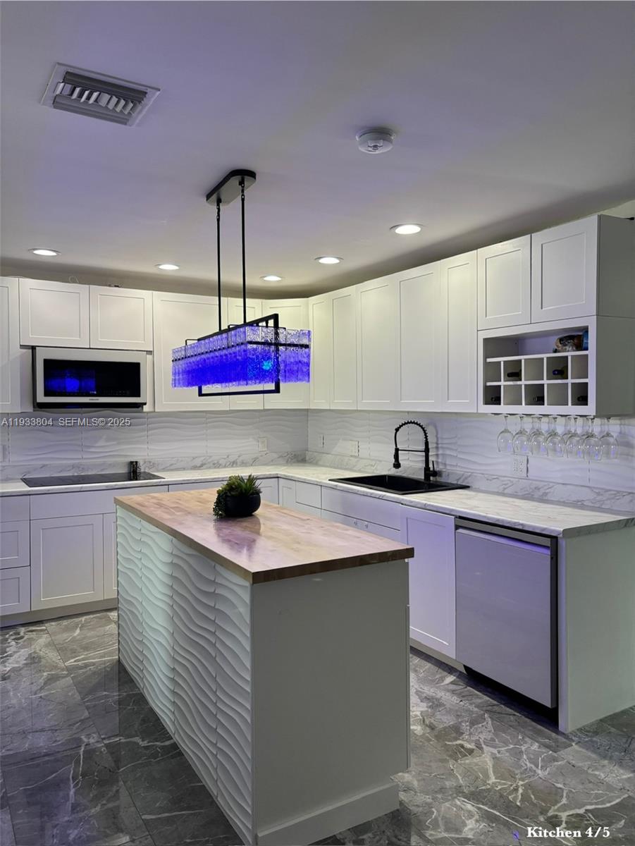 607 Maple Drive Margate, FL 33063 - Photo 27 of 37 a kitchen with kitchen island granite countertop a sink cabinets and window