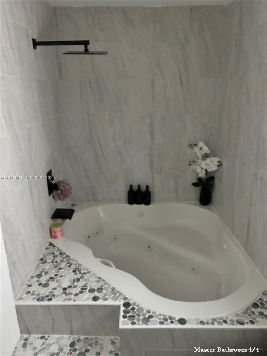 607 Maple Drive Margate, FL 33063 - Photo 8 of 37 a bathroom with a bathtub and a gate