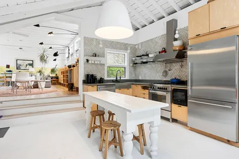 a kitchen with stainless steel appliances kitchen island granite countertop a refrigerator and a stove