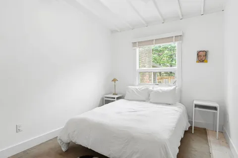 a bedroom with a bed and a window