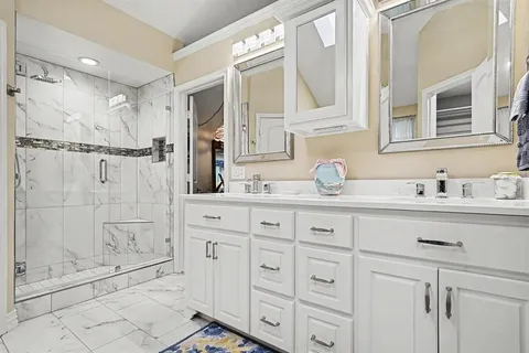 a bathroom with a granite countertop sink a mirror and shower