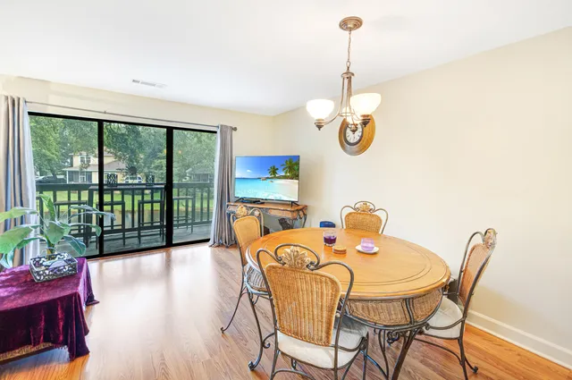 a dining room with furniture a chandelier and wooden floor