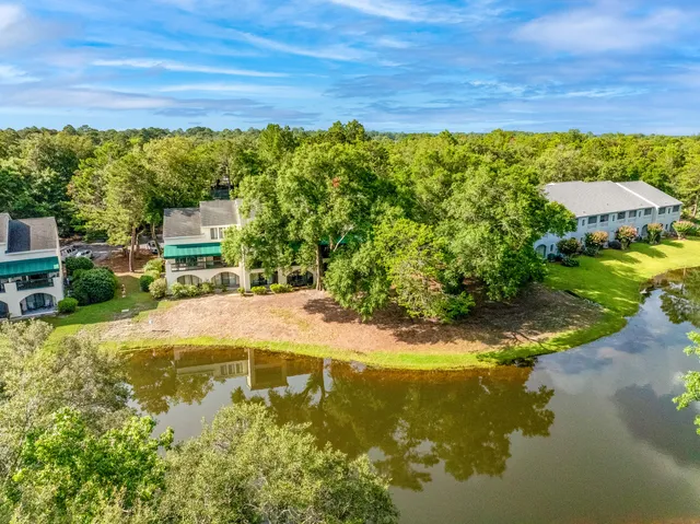 a view of a swimming pool with lawn chairs under an umbrella