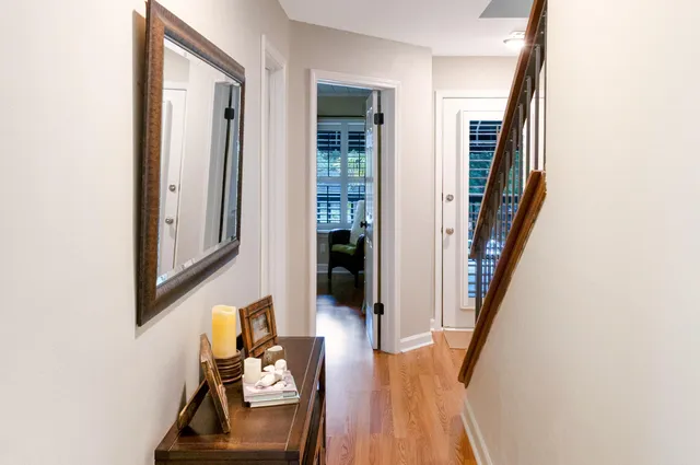 a view of a hallway with wooden floor and staircase