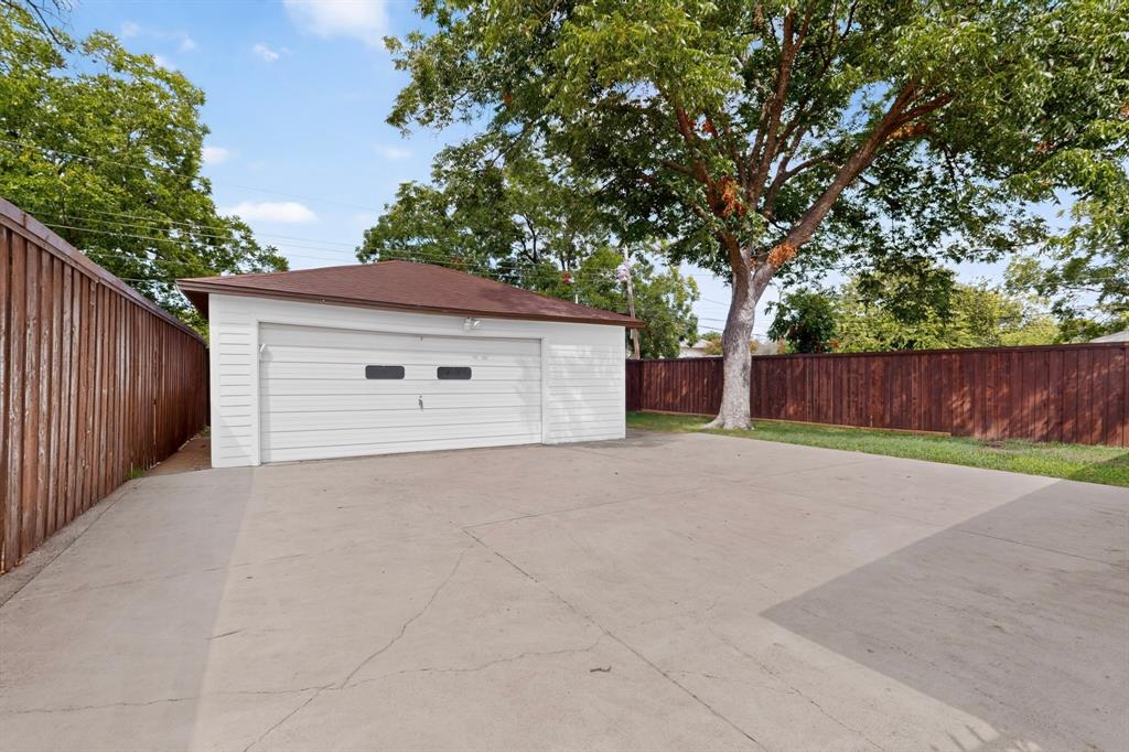 4404 Astor Road Mesquite, TX 75150 - Photo 35 of 38 Detached garage with a white paneled door, concrete driveway, and brown privacy fencing