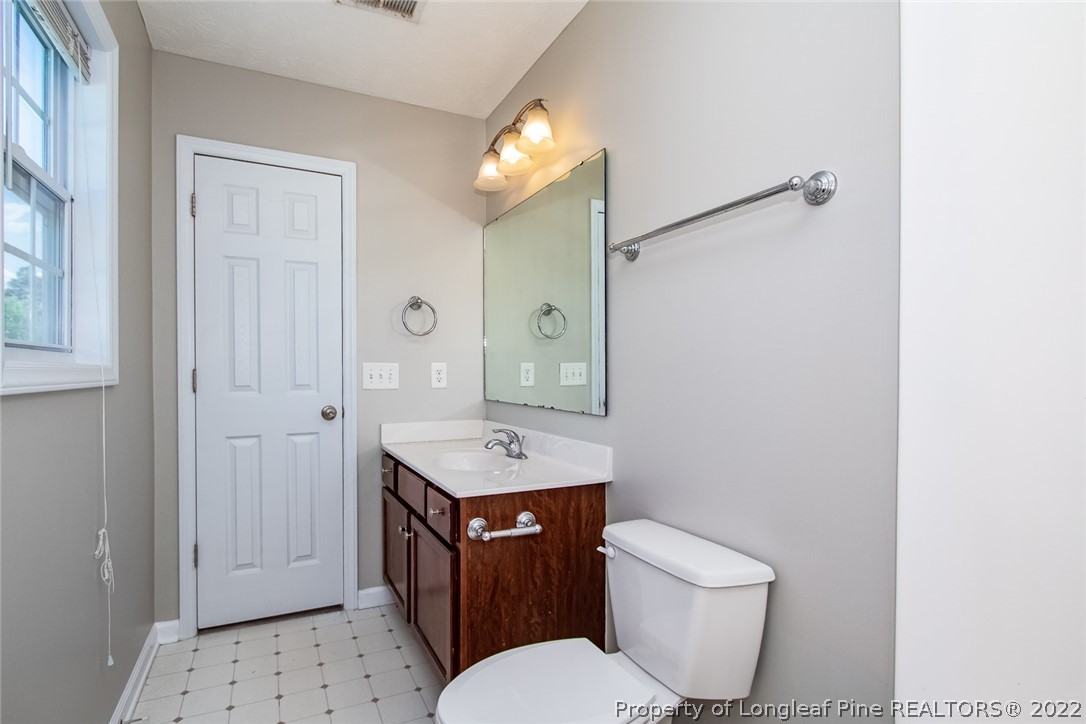 147 Boston Harbor Cameron, NC 28326 - Photo 19 of 27 a bathroom with a toilet a sink a mirror and a window