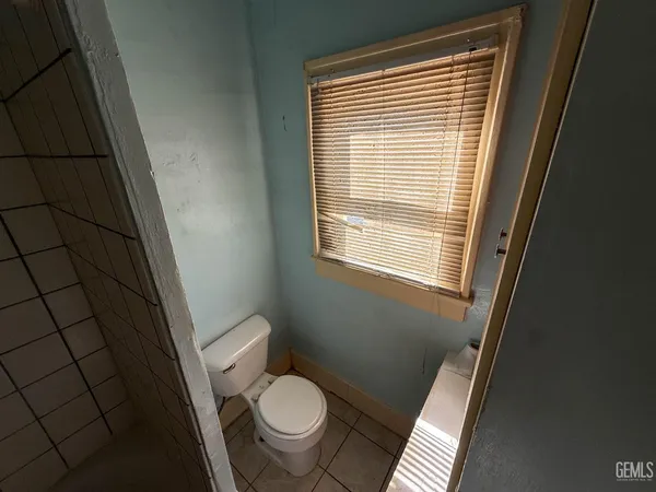 a toilet sitting in a bathroom next to a window