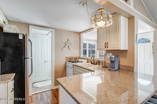 a kitchen with stainless steel appliances granite countertop a sink a stove and a refrigerator