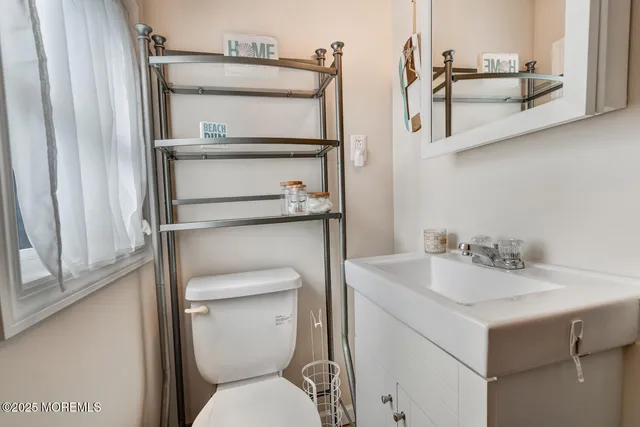 a bathroom with a toilet sink and mirror