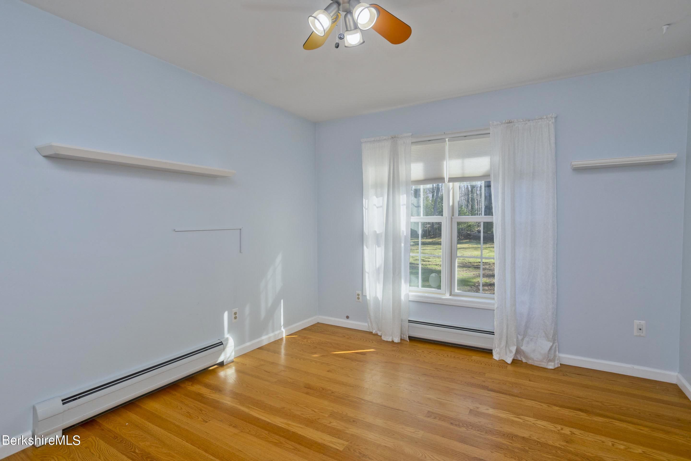 495 West Center Road Otis, MA 01253 - Photo 27 of 46 an empty room with wooden floor and windows