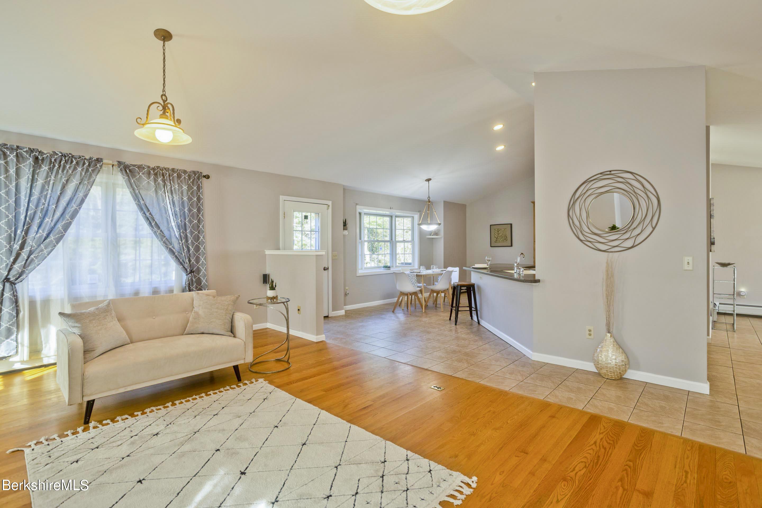 495 West Center Road Otis, MA 01253 - Photo 8 of 46 a living room with furniture a clock on wall and a dining table