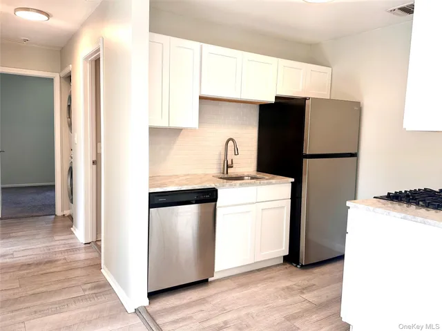 a kitchen with metallic refrigerator a sink and dishwasher