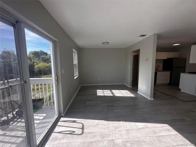 a view of a hallway with wooden floor and a bathroom