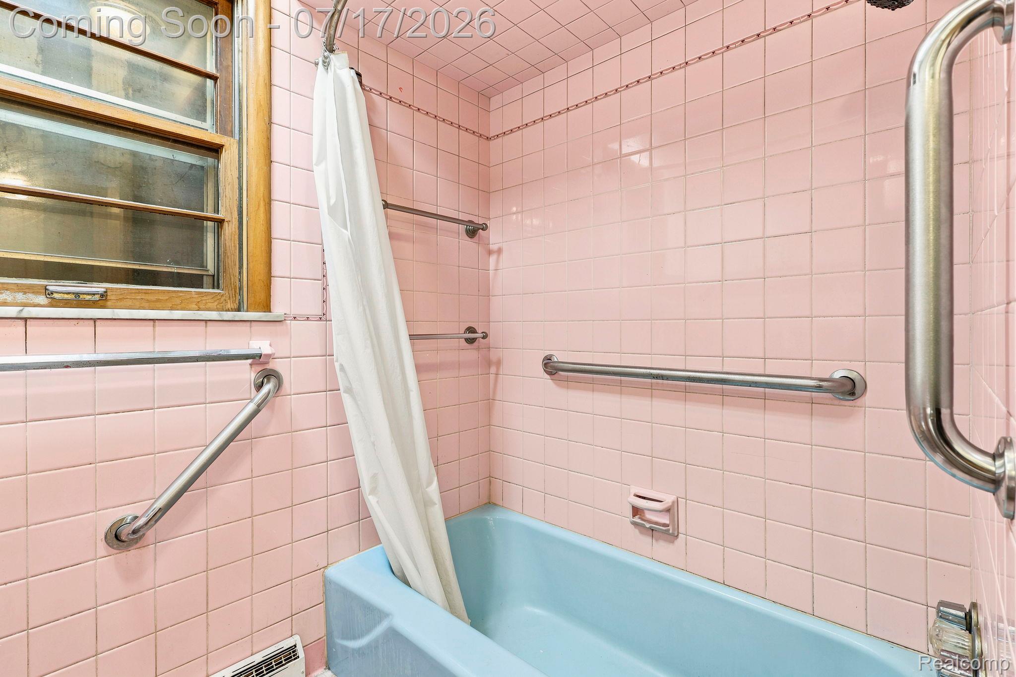 9805 Dolan Road Columbus, MI 48063 - Photo 15 of 39 Bathroom featuring pink square tile walls and a light blue bathtub