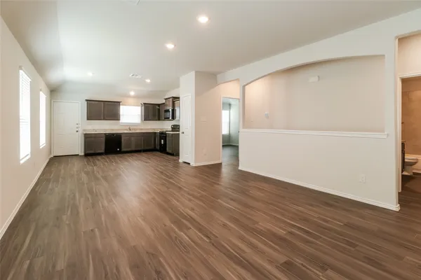 an empty room with wooden floor and white walls