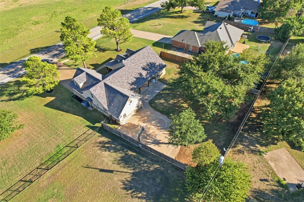 207 Dennis Road Lipan, TX 76462 - Photo 37 of 40 Expansive property with a multi-gabled roofline, stone and siding exterior, concrete driveway, and mature landscaping