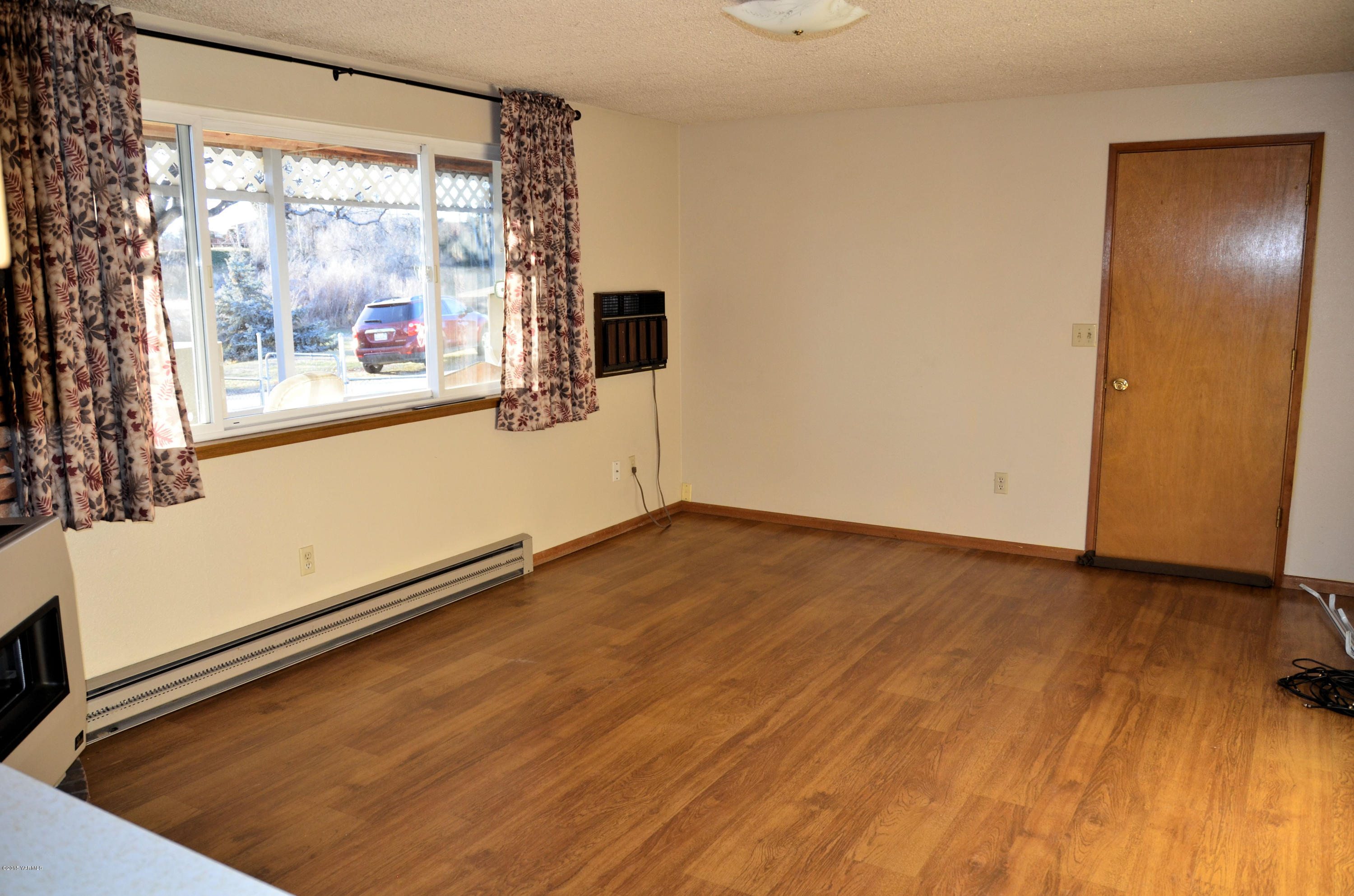 10814 Summitview Road Yakima, WA 98908 - Photo 10 of 16 a view of an empty room with wooden floor and a window