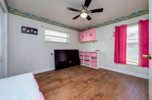 a room with ceiling fan and windows