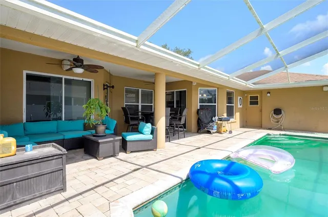 a view of a patio with table and chairs potted plants and floor to ceiling window