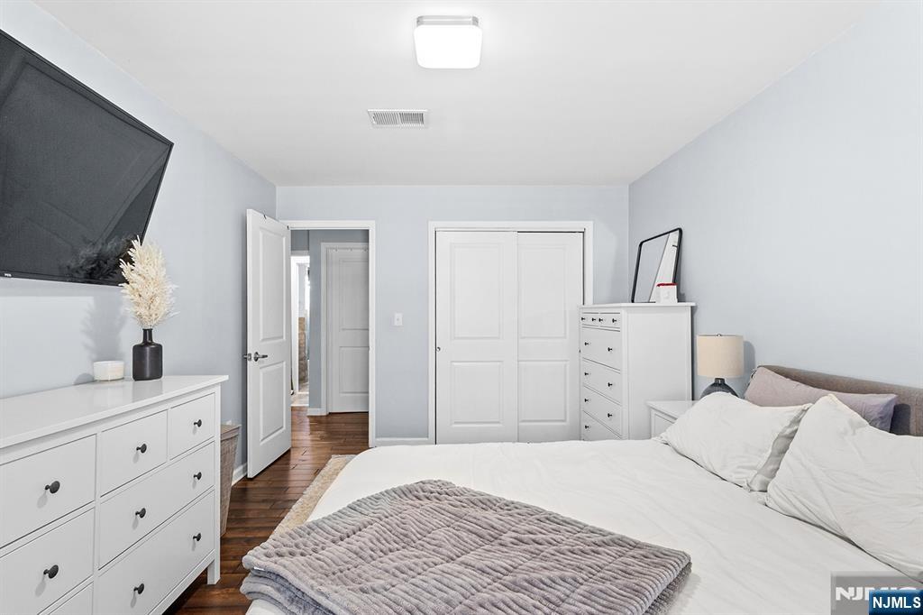 63-69 Rome Street, Unit 5K Newark, NJ 07105 - Photo 8 of 11 a bedroom with a bed and a dresser in it