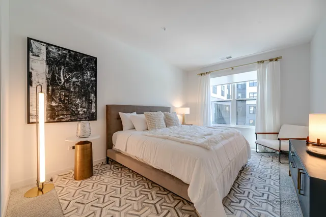 a bedroom with a bed and a lamp on table