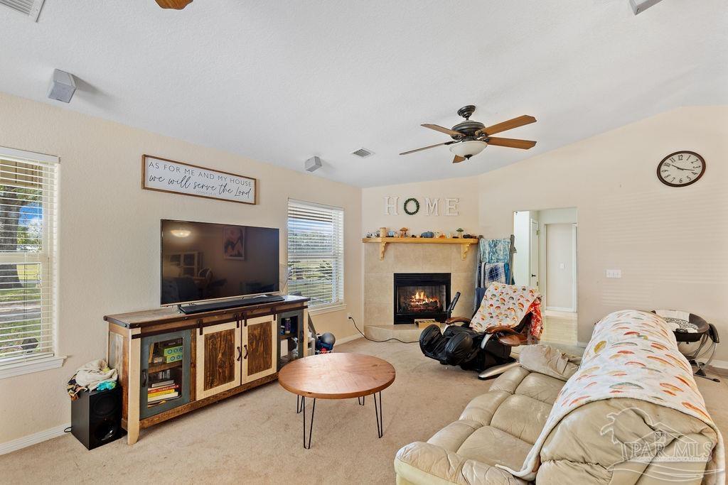 8240 Tidwell Road Pace, FL 32571 - Photo 15 of 41 a living room with furniture a flat screen tv and a fireplace