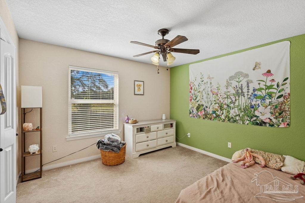 8240 Tidwell Road Pace, FL 32571 - Photo 24 of 41 a bedroom with a bed and a chandelier