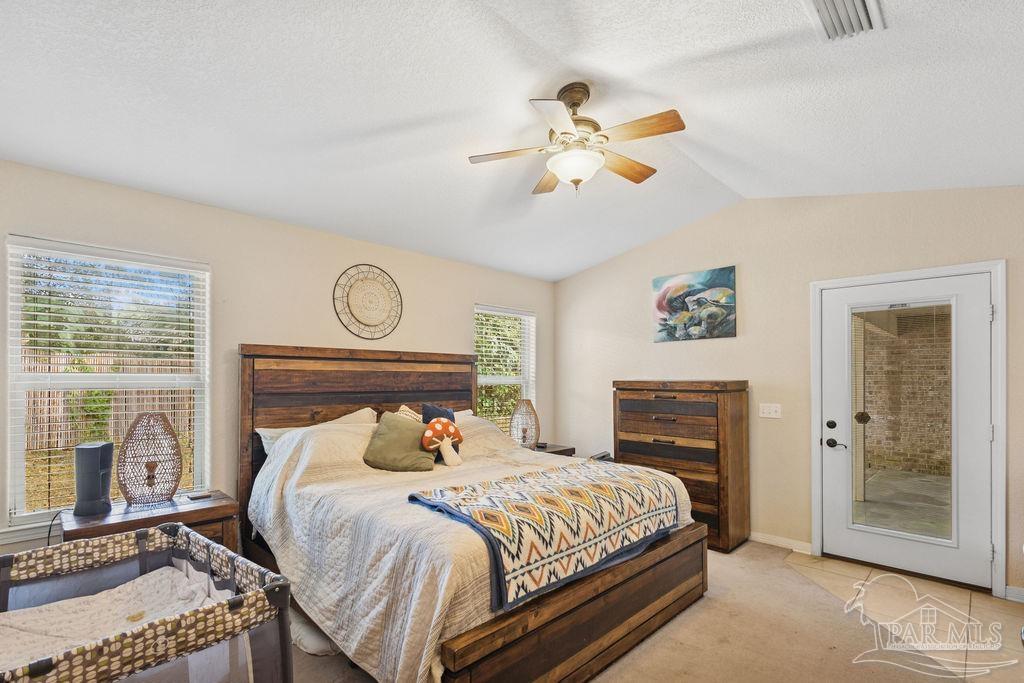 8240 Tidwell Road Pace, FL 32571 - Photo 25 of 41 a bedroom with a bed a window and a chandelier