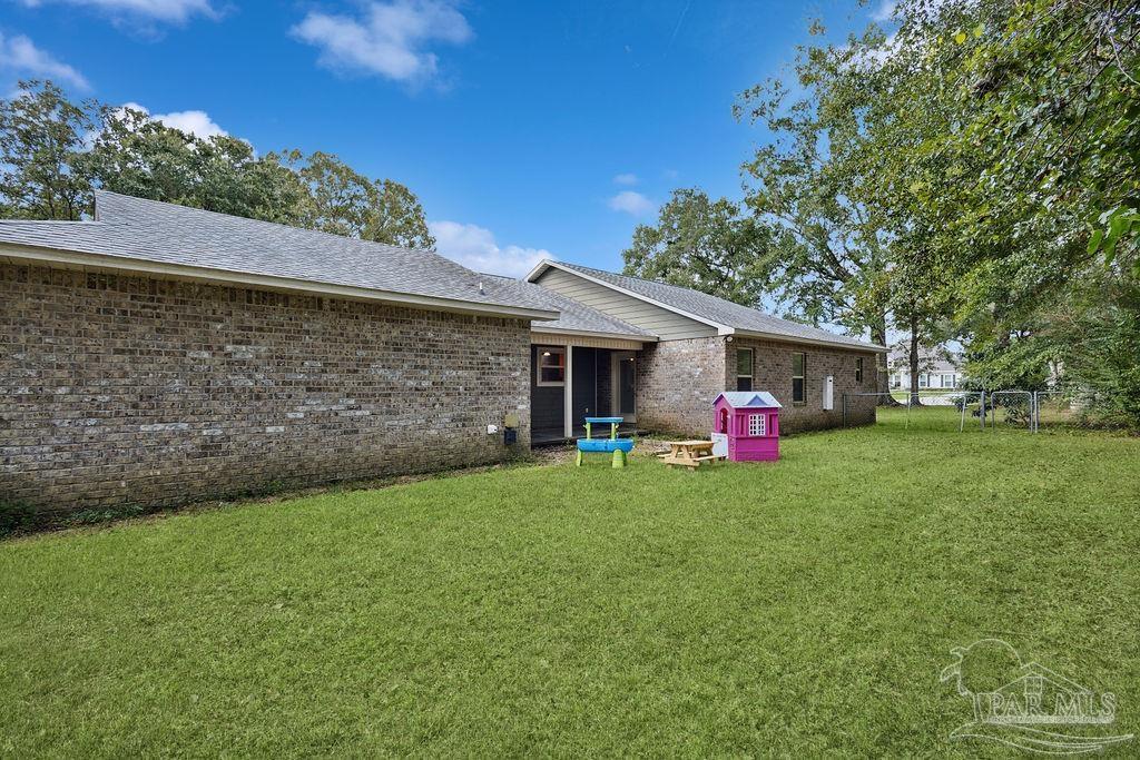 8240 Tidwell Road Pace, FL 32571 - Photo 29 of 41 a front view of a house with porch and garden