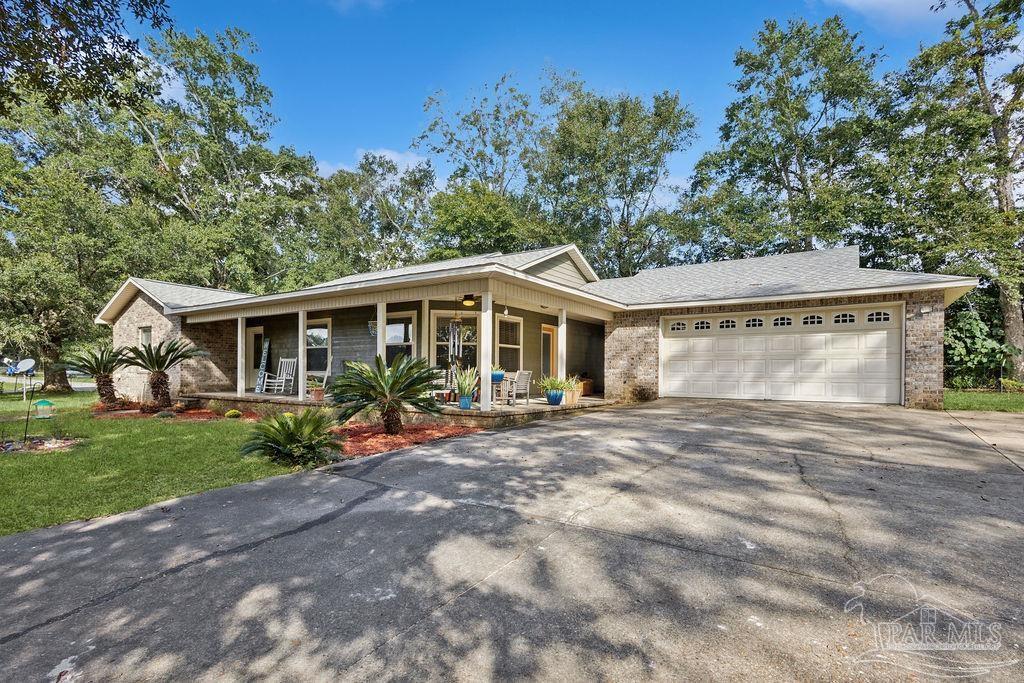 8240 Tidwell Road Pace, FL 32571 - Photo 3 of 41 a view of a house with backyard and garden
