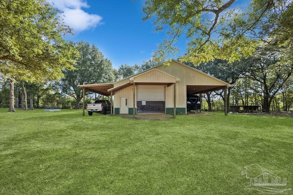 8240 Tidwell Road Pace, FL 32571 - Photo 39 of 41 a front view of a house with a garden