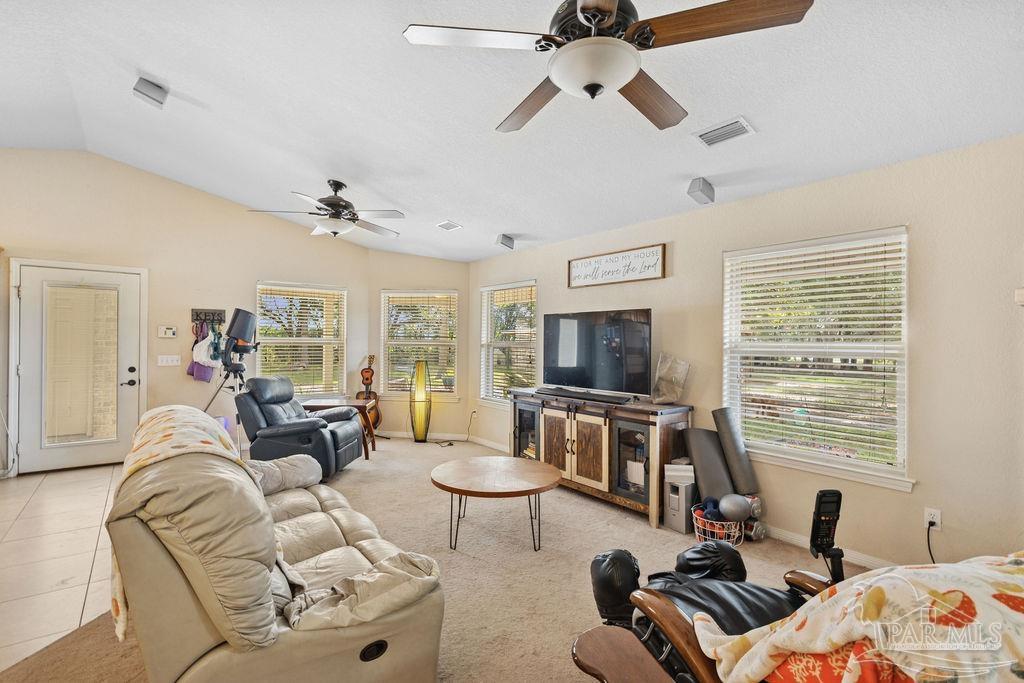 8240 Tidwell Road Pace, FL 32571 - Photo 9 of 41 a living room with furniture a flat screen tv and a window