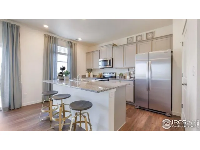 a kitchen with a refrigerator a table and chairs
