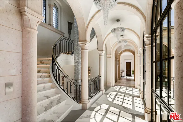 a view of staircase with lots of frames on wall and a large window
