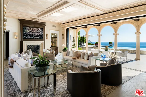 a living room with large windows and a table