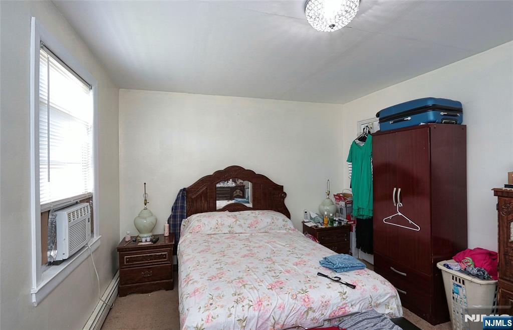 949 Front Plainfield, NJ 07062 - Photo 14 of 15 a bedroom with a bed and a potted plant on the dresser
