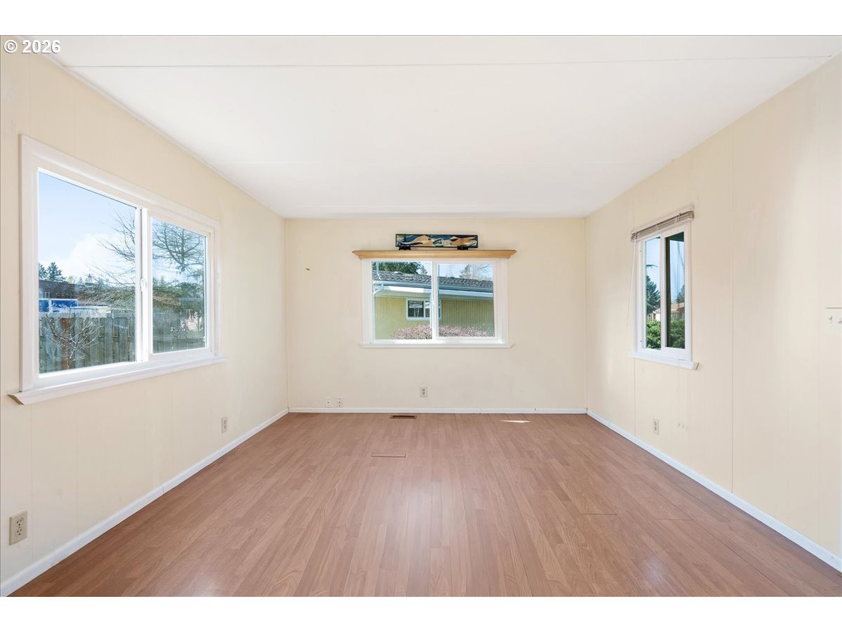 1418 Pine Street, Unit 7 Silverton, OR 97381 - Photo 6 of 27 an empty room with wooden floor and windows