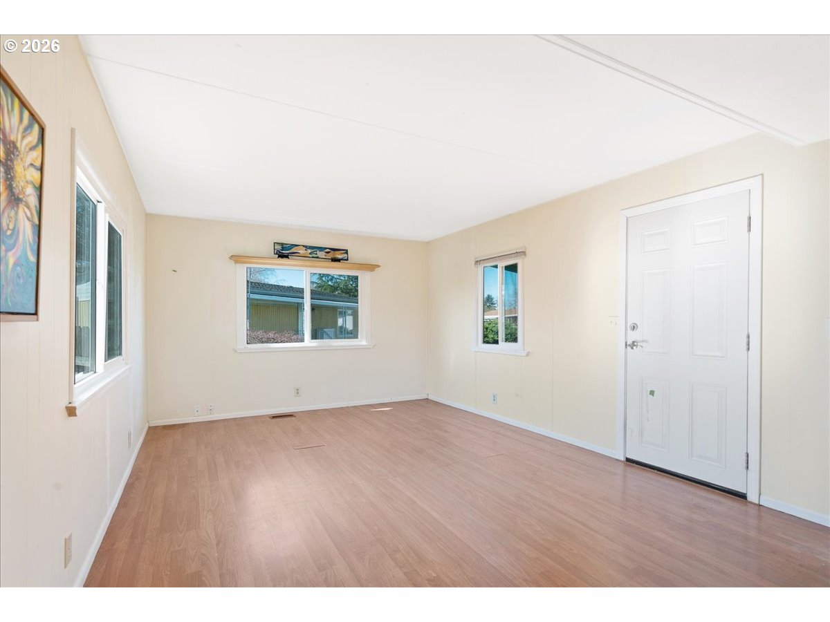 1418 Pine Street, Unit 7 Silverton, OR 97381 - Photo 7 of 27 a view of an empty room with wooden floor and a window