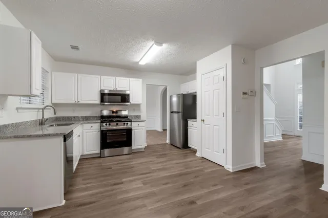 a kitchen with stainless steel appliances granite countertop a refrigerator stove and sink
