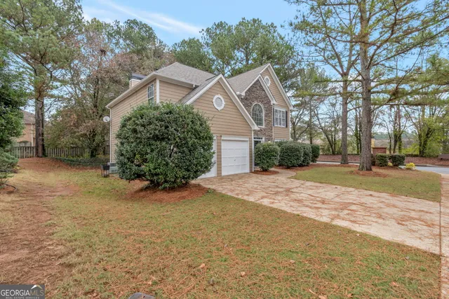 a view of a large house with a large tree and yard