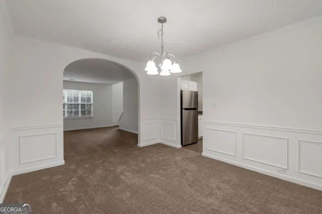 an empty room with chandelier and windows