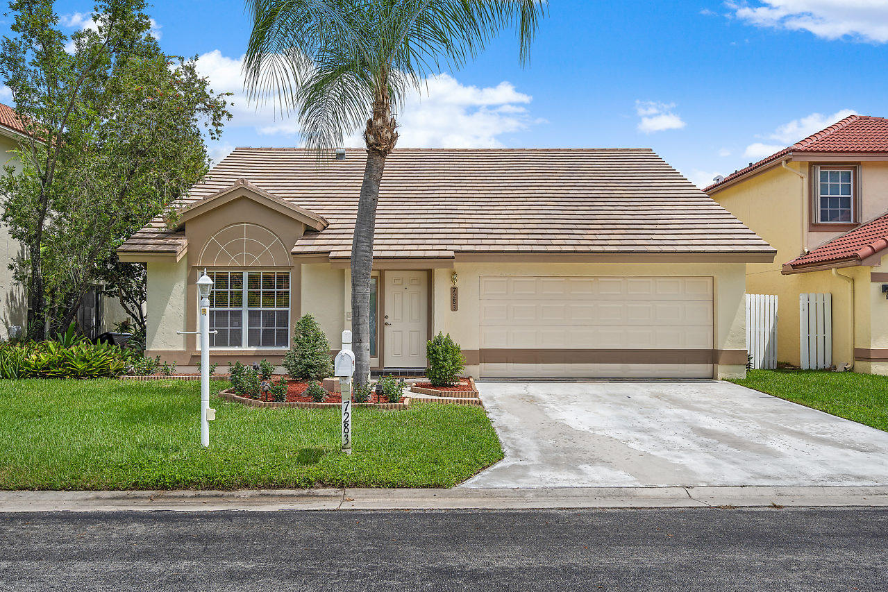 7283 Shell Ridge Terrace Lake Worth, FL 33467 - Photo 1 of 32 a front view of a house with a garden and plants