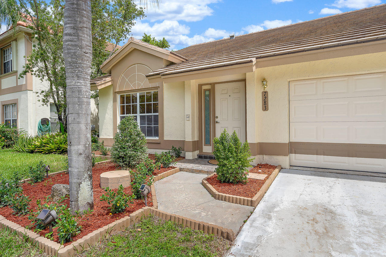 7283 Shell Ridge Terrace Lake Worth, FL 33467 - Photo 30 of 32 a view of a house with a small yard and plants