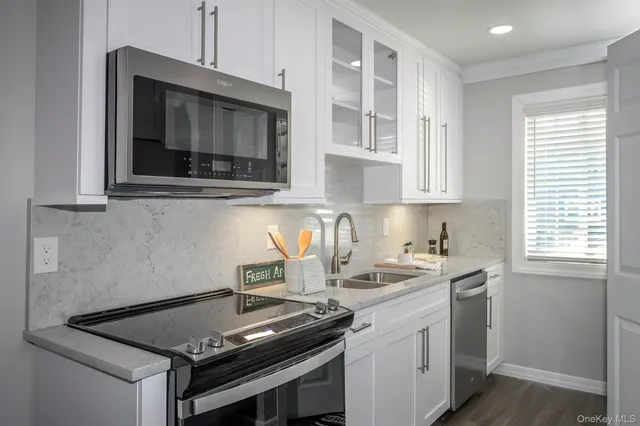 a kitchen with stainless steel appliances granite countertop a sink stove and microwave