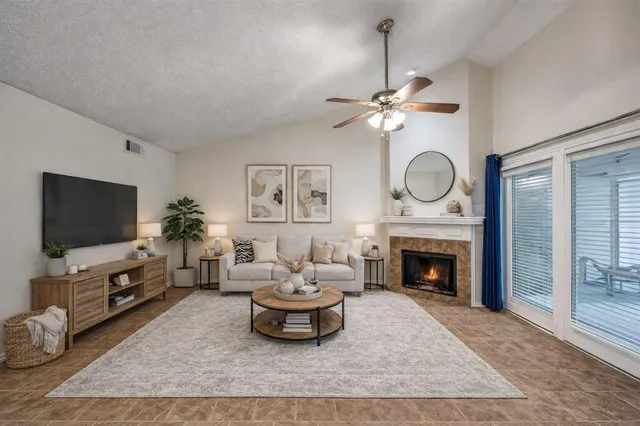 a living room with furniture a fireplace and a flat screen tv