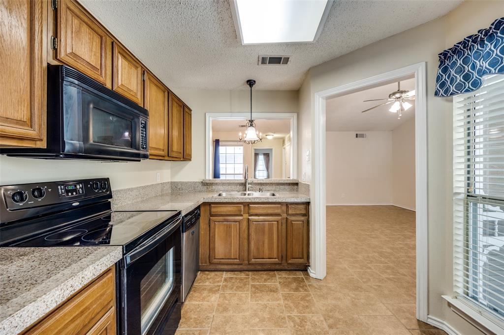 14277 Preston Road, Unit 423 Dallas, TX 75254 - Photo 12 of 31 a kitchen with stainless steel appliances granite countertop a stove a sink and a microwave
