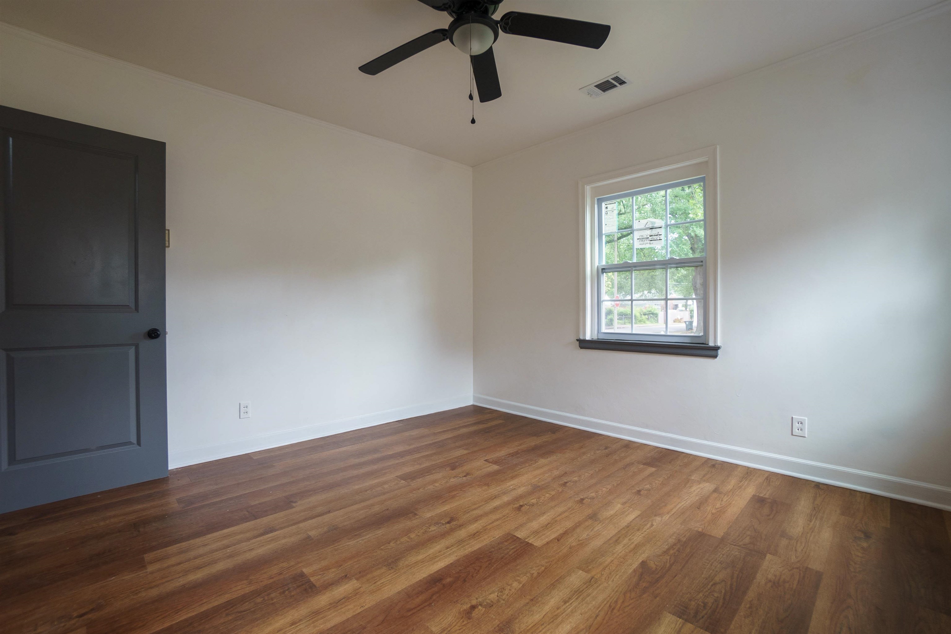 1069 Railton Road Memphis, TN 38111 - Photo 12 of 17 a view of an empty room with wooden floor and a window