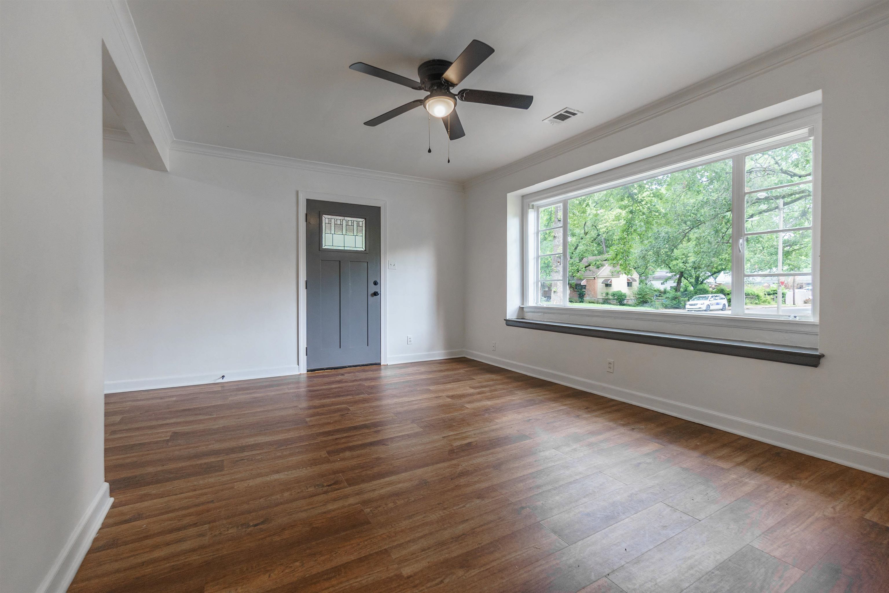 1069 Railton Road Memphis, TN 38111 - Photo 5 of 17 a view of an empty room with wooden floor and a window