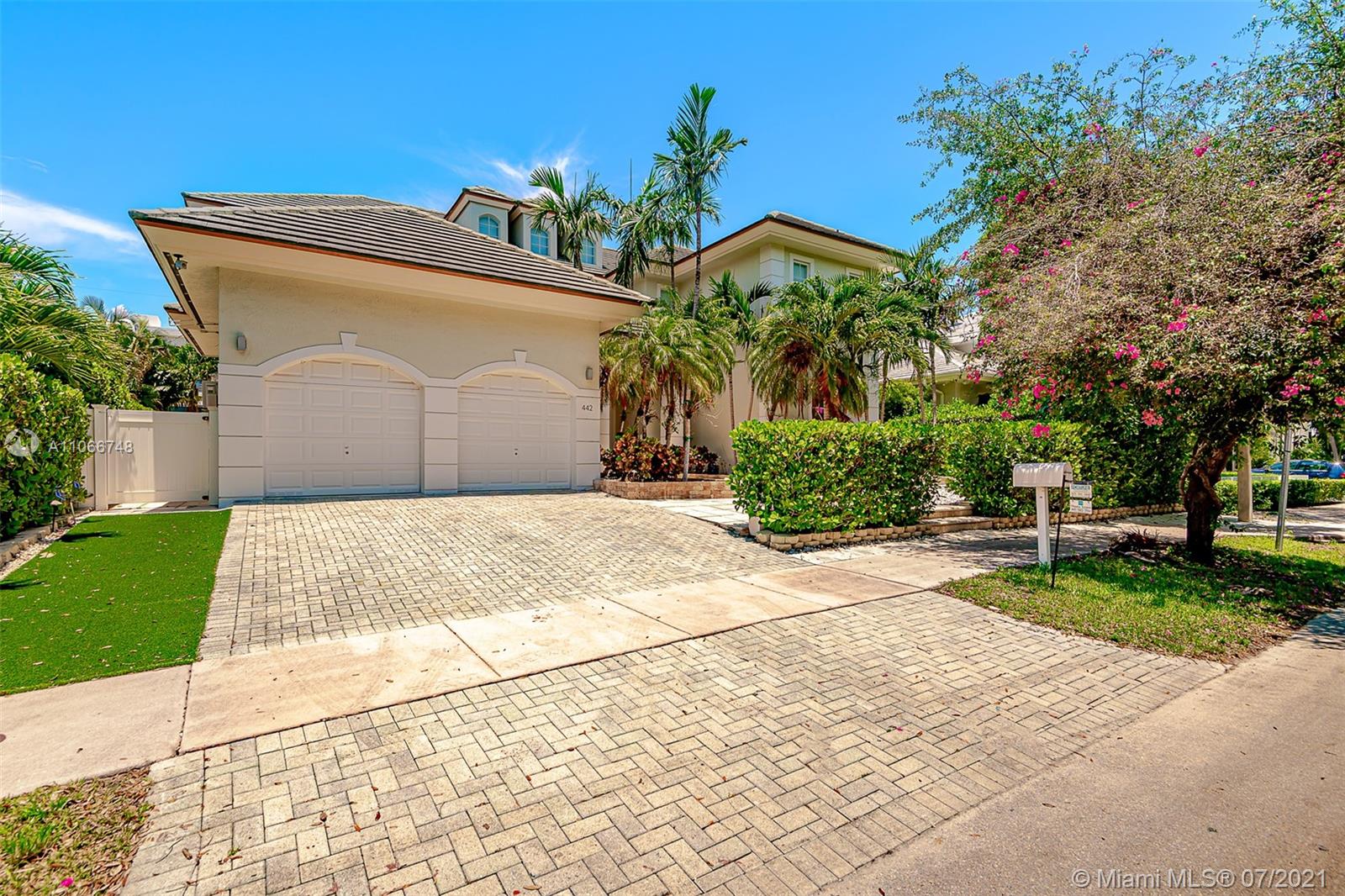 442 Woodcrest Road Key Biscayne, FL 33149 - Photo 2 of 48 a front view of a house with a garden
